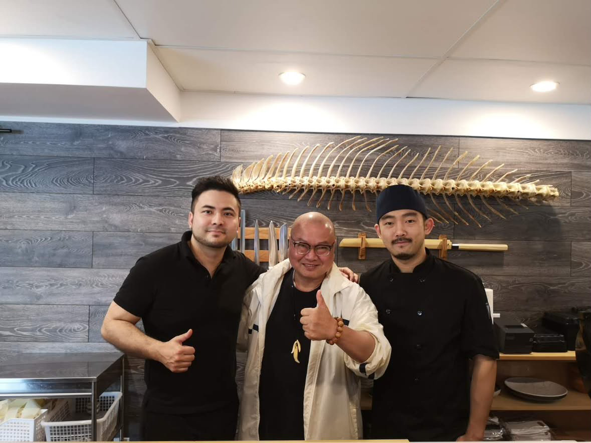 Sam 主厨到访 Taka’s Sushi,在蓝鳍金枪鱼骨架下的吧台前合影