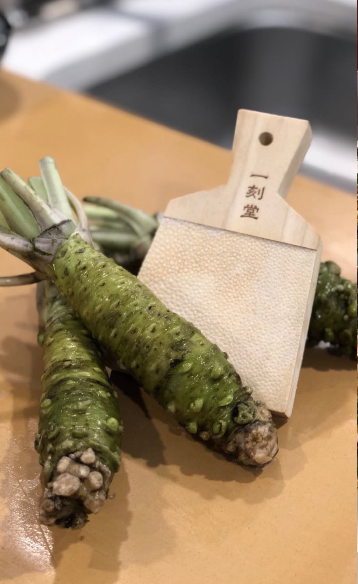 木板上的完整新鲜山葵根茎与传统磨板