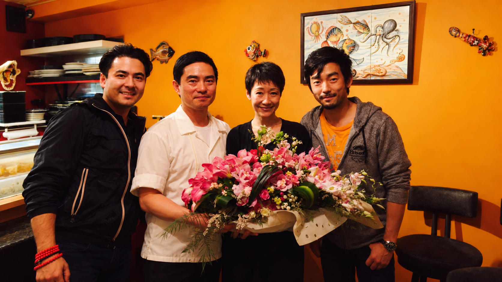 Dylan、Taka-san、Megumi 与 Michael 在 Taka’s 原店与鲜花合影